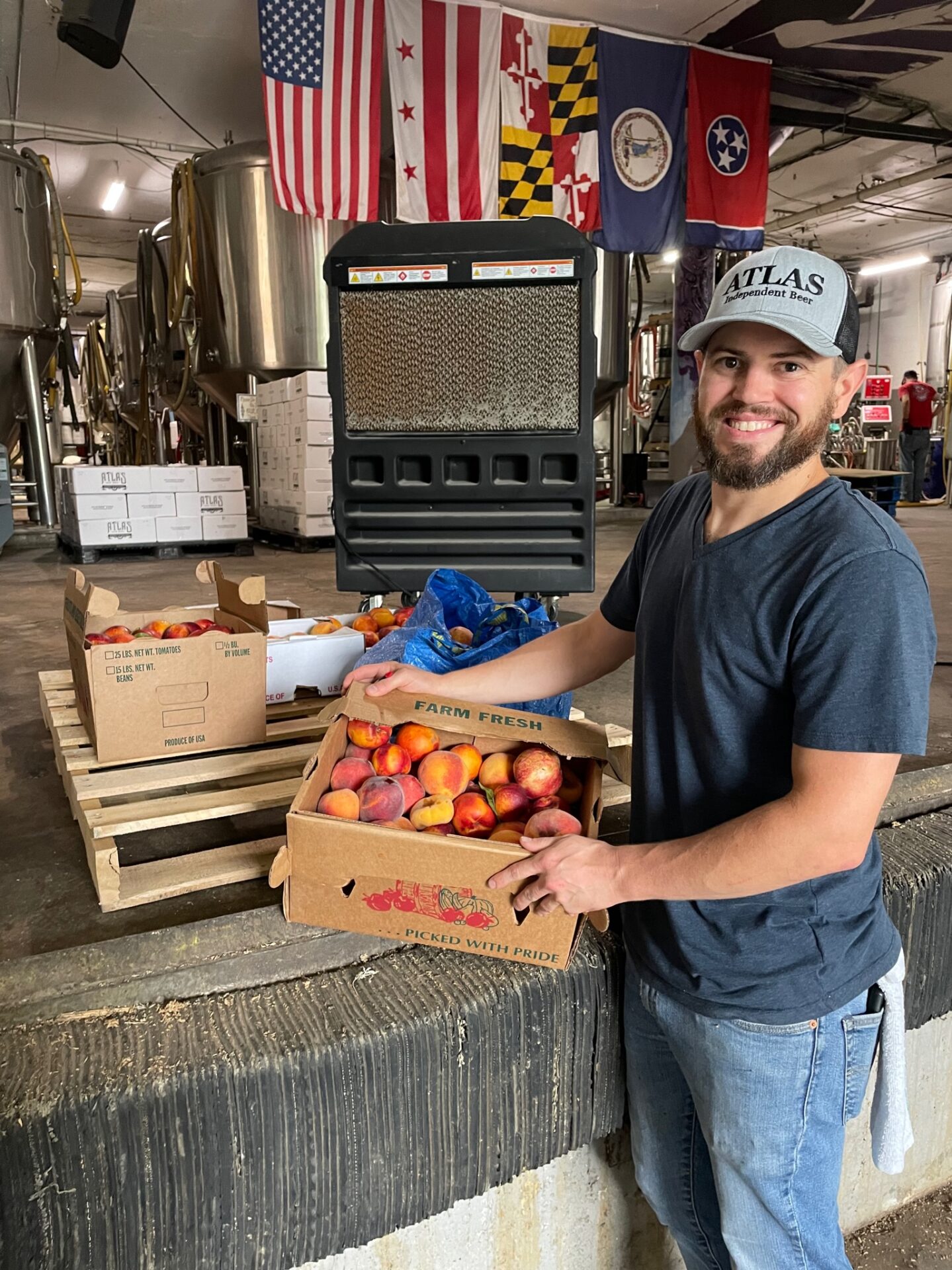 A Food Rescue US DC volunteer with a box of donated peaches