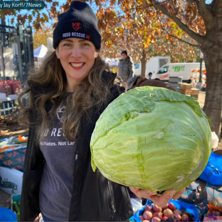 Food Rescue US DC volunteer Kristina holds a cabbage to the camera