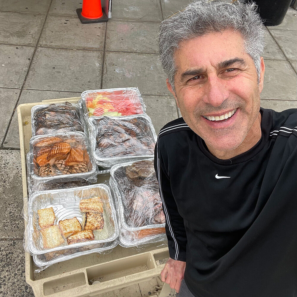 Man smiling with trays of food